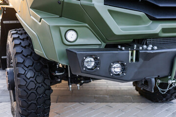 Military equipment and army equipment.. Exhibition of armored offroad truck with towing and protection gear. Presentation of durable military vehicle exhibiting suspension armor and towing © NastyaPhoto