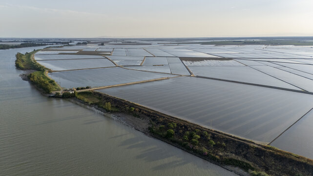 Aerial view of the flooded rice fields of Isla Minima along the riverbank with geometric patterns under a clear sky Sevilla, Andalucia, Spain.