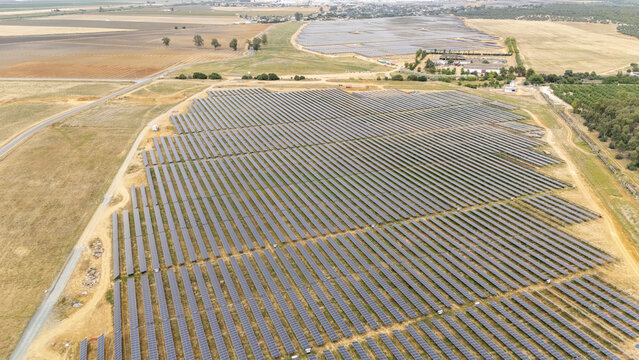 Aerial view of a large solar panel farm with rows of photovoltaic modules across a dry rural landscape Andalusia, Spain.