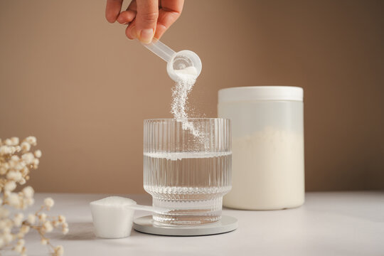 Collagen peptides supplement preparation with powder added to glass of water