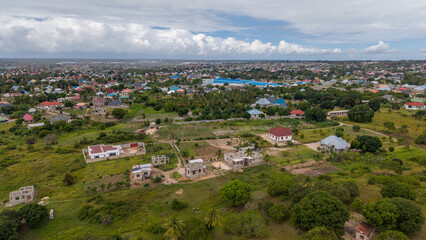 Fototapeta premium Aerial view of Kibada–Kigamboni in Dar es Salaam showcasing rural farming, crops, and river landscapes within an agricultural settlement.
