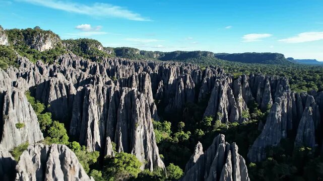 Breathtaking Aerial View of Sharp Limestone Karst Formations and Lush Jungle ideal for travel documentaries and nature backgrounds.