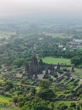 Aerial view of the ancient Prambanan Temple complex with its towering stone spires surrounded by lush green gardens in Kecamatan Prambanan, Daerah Istimewa Yogya, Indonesia.