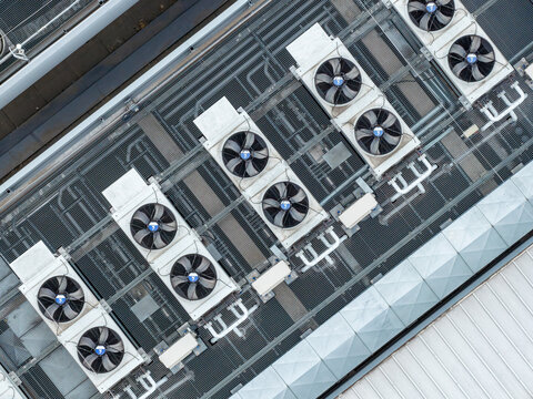 Aerial view of industrial cooling units and large ventilation fans on the rooftop of the secured datacenter Warszawa, Wojewodztwo mazowieckie, Poland.