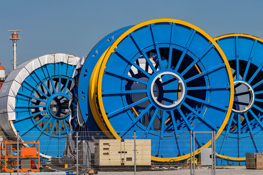 Thermoplastic Composite Pipe industrial spools are located outside on a fenced factory site