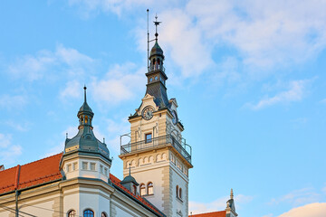 Obraz premium Historic european clock tower against blue sky and clouds