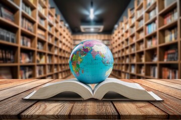 Globe and open book resting on a wooden table in a library with blurred bookshelves © BillionPhotos.com