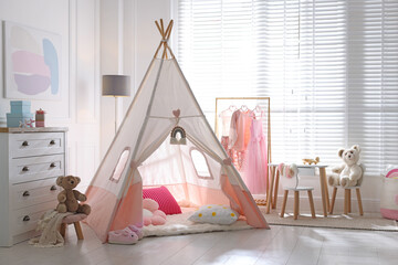 Cute wigwam, clothes, cushions and toys in stylish child's room © New Africa