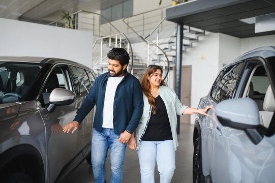 Indian couple choosing new car in modern showroom