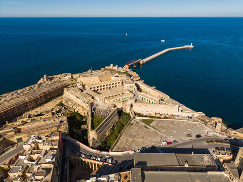 Aerial view of the historic star-shaped Fort St Elmo with its massive stone walls overlooking the deep blue Mediterranean Sea and breakwater in Valletta, Port Region, Malta.