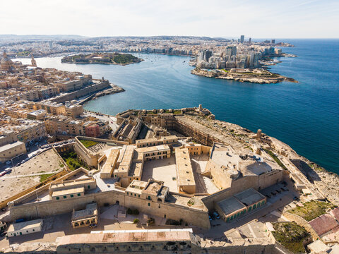 Aerial view of the historic Abercrombie's Bastion and Fort Saint Elmo overlooking the Mediterranean Sea and the Sliema skyline under a clear sky in Valletta, Port Region, Malta.