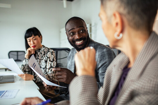 Diverse business team discussing paperwork in office