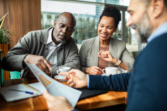 Mature couple meeting with financial advisor at cafe