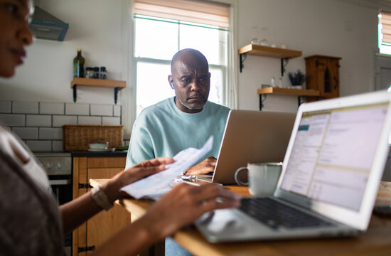 Mature man and partner reviewing household finances at kitchen table