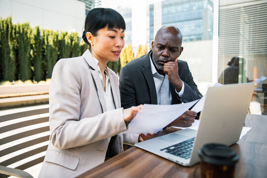 Two business colleagues reviewing documents on office terrace