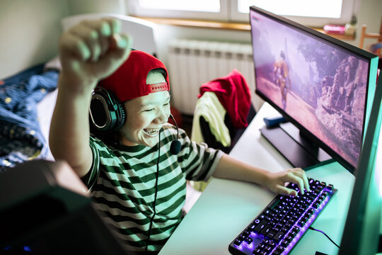 Excited child playing pc game at home