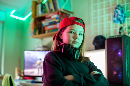 Confident teen gamer with headset in neon-lit bedroom