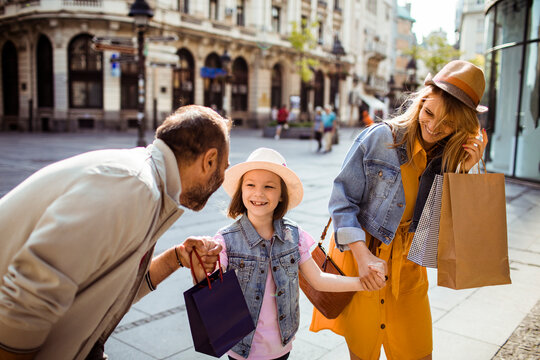 Happy family shopping on a sunny european city street