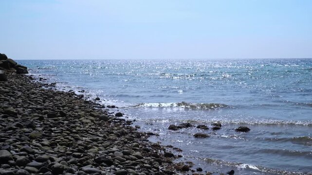 Rocky Coastline with Clear Blue Sea and Gentle Surf &ndash; 4K Stock Video