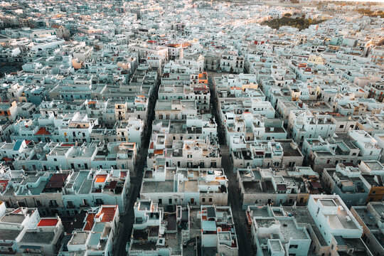Aerial view of the dense historic center with white houses and narrow streets in Polignano a Mare, Apulia, Italy.
