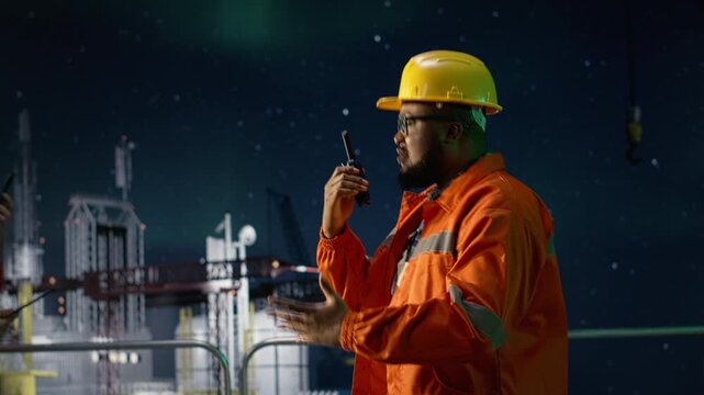Engineering team on drilling barge doing radio coordination during embargo while offshore platform african american man and coworker communicate to mitigate oil crisis disruptions, northern lights.