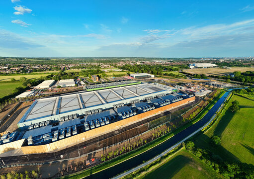 Aerial view of the Google Data Centre - Waltham Cross with its large industrial structure and cooling systems under a clear blue sky in Cheshunt, England, United Kingdom.