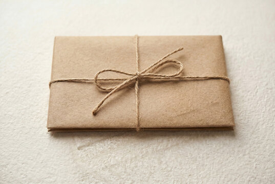 Blank brown kraft paper envelope tied with rustic jute twine string