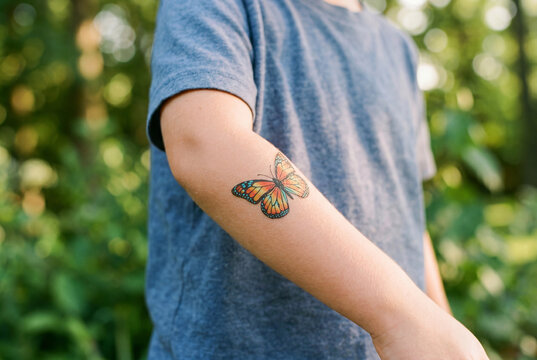 Childs arm showing colorful butterfly temporary tattoo outdoors
