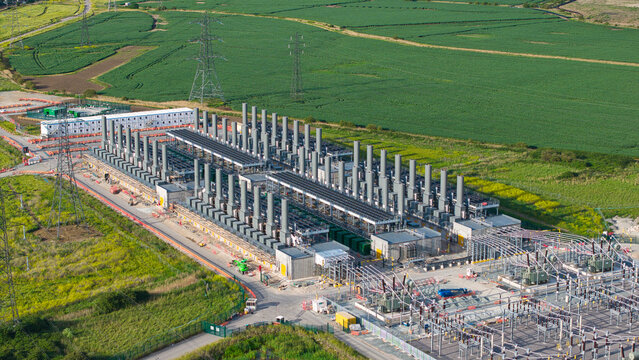 Aerial view of the Thurrock Battery Energy Storage BESS and Flexible Generation Plant with industrial stacks and electrical infrastructure in Thurrock, England, United Kingdom.
