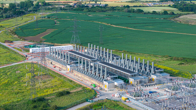 Aerial view of the Thurrock Battery Energy Storage BESS and Flexible Generation Plant with industrial infrastructure and exhaust stacks in Thurrock, England, United Kingdom.