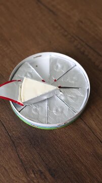 Close-up of triangle processed cream cheese portion in open foil wrapper
