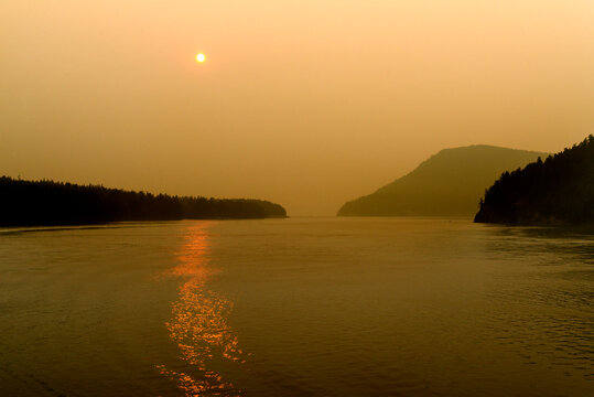 Canada, BC, Salish Sea, Gulf Islands.  The sun and the view obscured by forest fire smoke