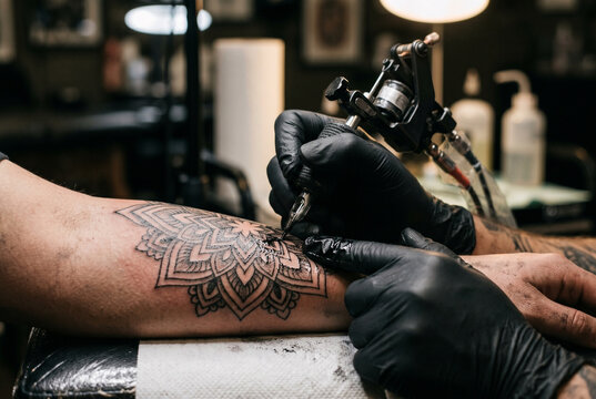 Tattoo Artist Creating Mandala Arm Tattoo with Machine