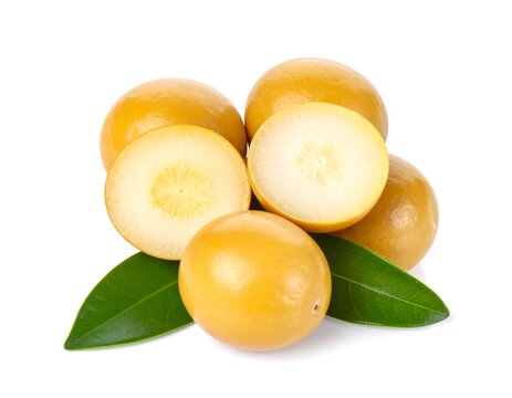 Organic marula fruits, whole and sliced, on green leaves