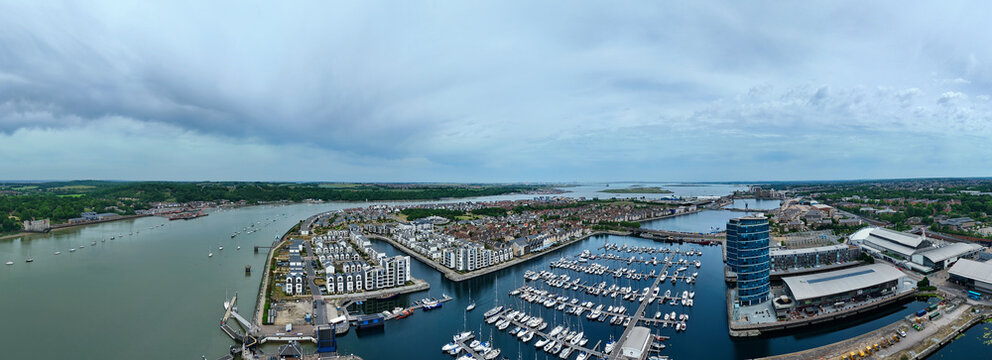 Aerial view of Saint Mary's Island featuring the marina filled with boats, modern residential buildings, and the River Medway under a cloudy sky in Rochester, England, United Kingdom.