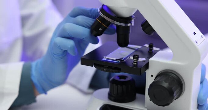 Laboratory testing. Scientist examining sample of milk under microscope indoors, closeup