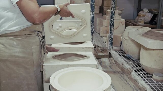Ceramic Artisan Working With Plaster Molds In Pottery Workshop