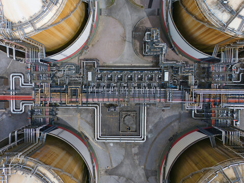 Aerial view of the Grain LNG terminal featuring large storage tanks and a complex network of industrial pipes in Wallend, England, United Kingdom.