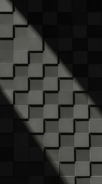 Dark background with textured wall of square blocks arranged in staggered pattern. Sunlight creates sharp shadows, adding sense of depth and dimension to geometric design, ideal for modern concepts.