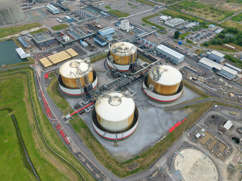 Aerial view of Grain LNG storage tanks with industrial infrastructure and surrounding green fields Wallend, England, United Kingdom.
