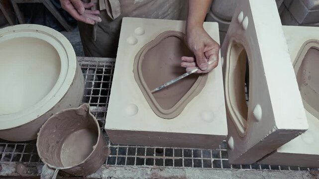 Ceramic Artisan Working With Plaster Molds In Pottery Workshop