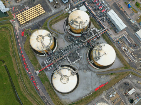 Aerial view of Grain LNG terminal featuring large storage tanks and complex industrial piping systems at Wallend, England, United Kingdom.