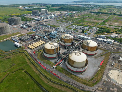 Aerial view of Grain LNG terminal featuring large storage tanks and industrial infrastructure surrounded by green fields in Wallend, England, United Kingdom.