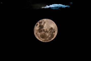 Fototapeta premium Waning Gibbous Moon Rising Amonst The Clouds