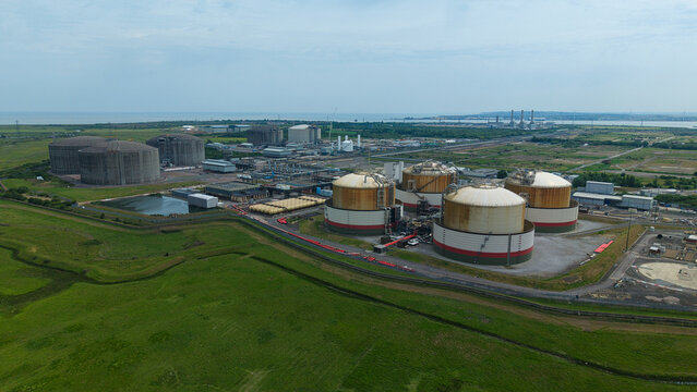 Aerial view of the Grain LNG terminal featuring large storage tanks and industrial infrastructure near the coast Wallend, England, United Kingdom.