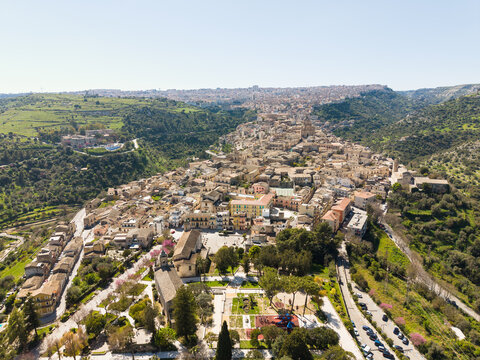 Aerial view of the historic hilltop town of Ragusa Ibla with its ancient stone buildings, baroque churches, and winding streets nestled in a lush green valley Ragusa, Sicily, Italy.