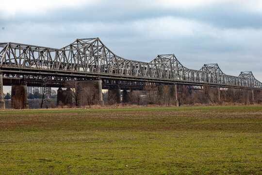Memphis, Tennessee / United States &ndash; Winter Season: Daylight view of the Hernando de Soto Bridge spanning the Mississippi River, seen from the Arkansas side, with the river flowing beneath and a clear
