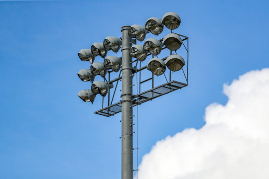 Stadium light over a baseball field with blue sky and puffy clouds in the background
