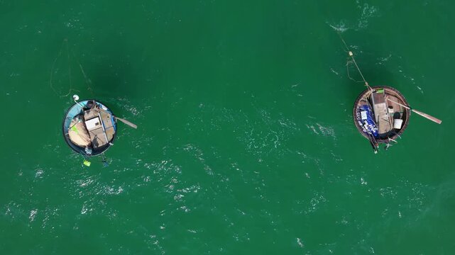 Aerial View Of Two Basket Boats Drifting Side By Side. Gentle Swell And Shimmering Water, Lone Boatmen Tending Oars, Serene Coastal Mood, Traditional Craft Showcased From Above.