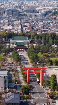 Aerial view of Heian shrine red torii gate and main hall in Kyoto Japan during spring cherry blossom season.